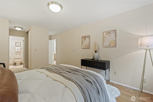 bedroom with ensuite bathroom and light hardwood / wood-style flooring