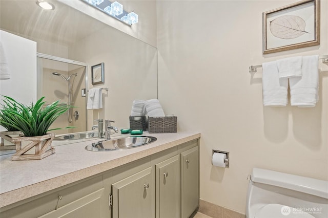 bathroom featuring toilet, vanity, and a shower with shower door