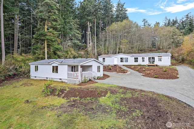 manufactured / mobile home featuring crawl space, driveway, and a porch