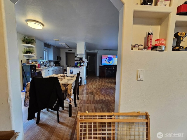 dining area featuring a textured wall and wood finished floors