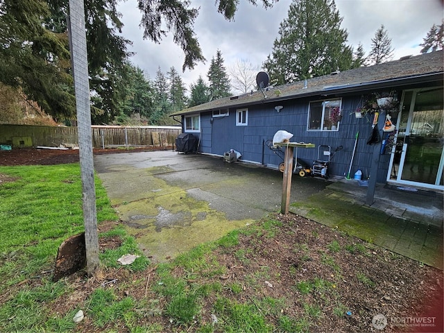 view of property exterior featuring a yard, fence, and a patio area