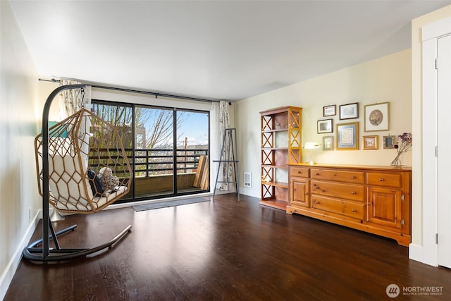 unfurnished room with dark wood-style flooring, visible vents, and baseboards