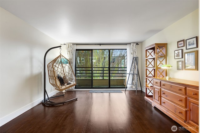 sitting room with dark wood-style flooring and baseboards