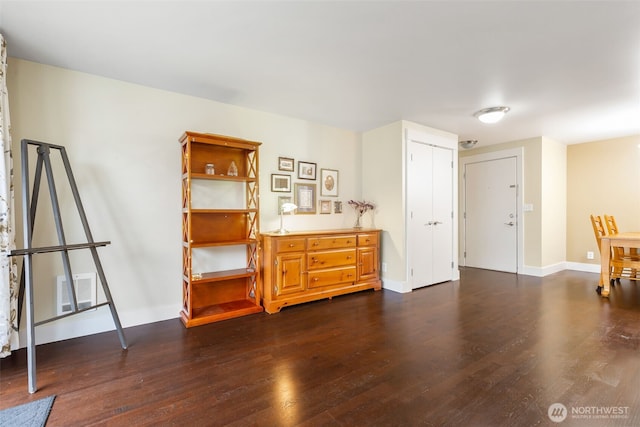 interior space with dark wood finished floors, visible vents, and baseboards