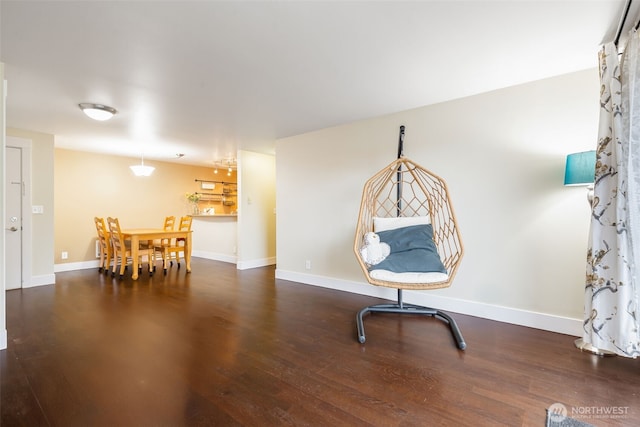 living area with baseboards and wood finished floors