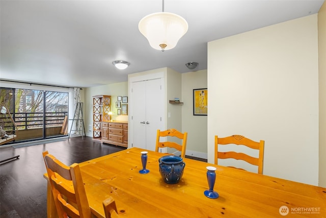 dining area with baseboards and wood finished floors