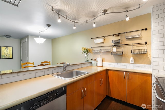 kitchen with light countertops, stainless steel dishwasher, brown cabinetry, and a sink