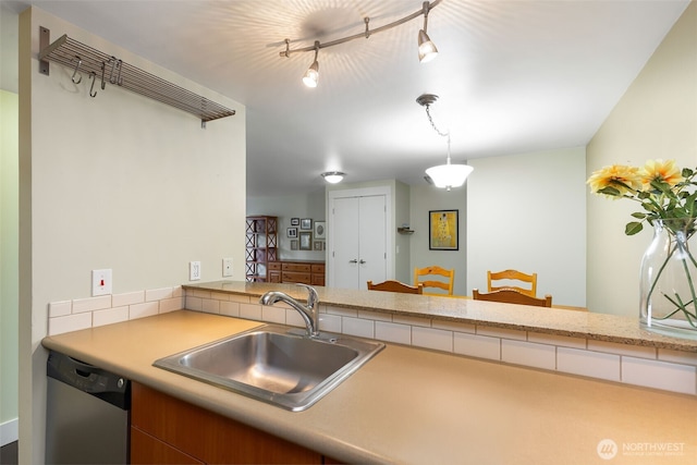 kitchen with dishwasher, hanging light fixtures, a sink, and light countertops