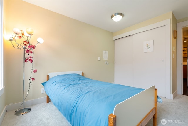 bedroom with a closet, carpet flooring, and baseboards