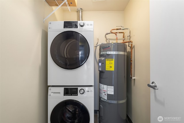 washroom featuring water heater, laundry area, and stacked washer / drying machine