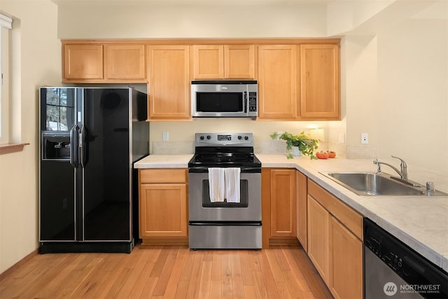 211 Broadway St, Cle Elum, WA 98922 - kitchen with light hardwood / wood-style floors, appliances with stainless steel finishes, sink, and light brown cabinetry