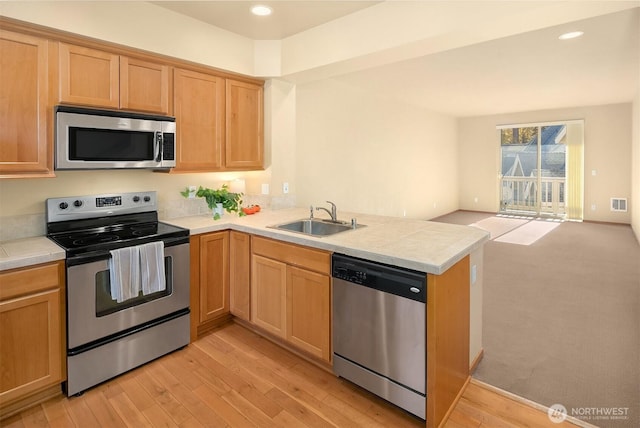 211 Broadway St, Cle Elum, WA 98922 - kitchen with light hardwood / wood-style flooring, sink, stainless steel appliances, kitchen peninsula, and tile counters