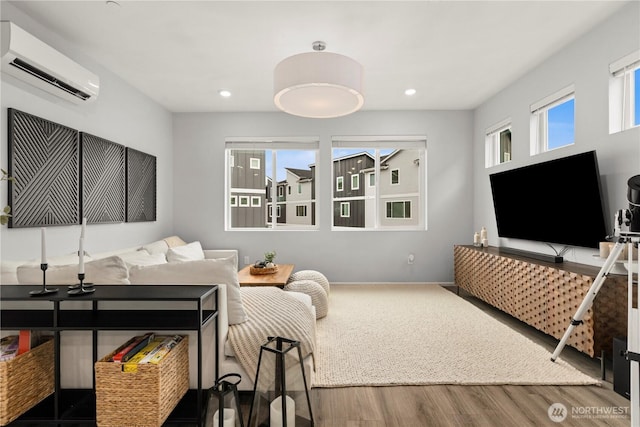 living room with baseboards, an AC wall unit, wood finished floors, and recessed lighting