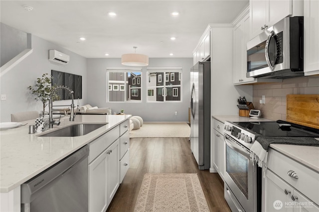 kitchen featuring hanging light fixtures, white cabinetry, stainless steel appliances, and a sink