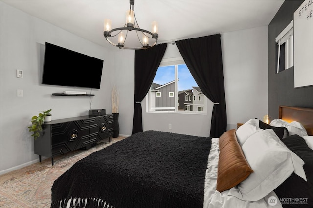 bedroom with baseboards and a notable chandelier