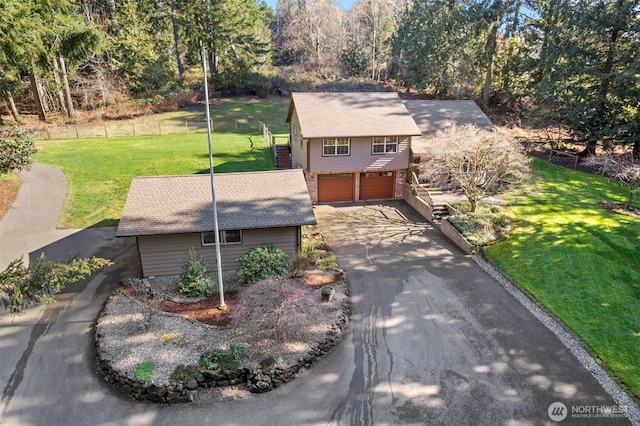 view of front of house with a garage, concrete driveway, and a front lawn