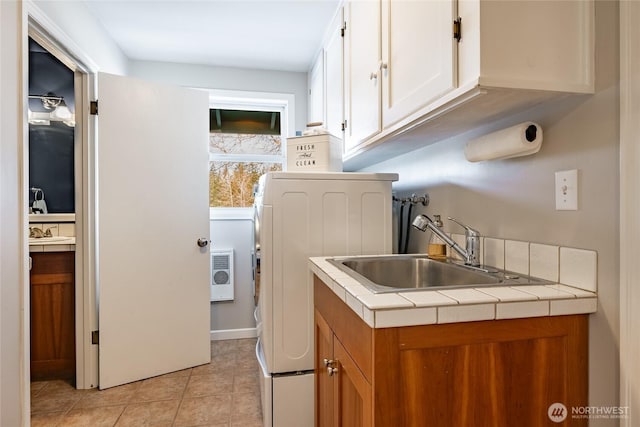 laundry room with cabinets, light tile patterned floors, sink, and washer / dryer