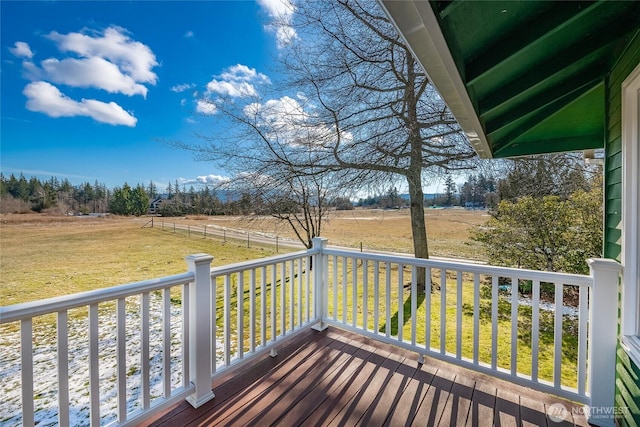 wooden deck with a rural view and a lawn