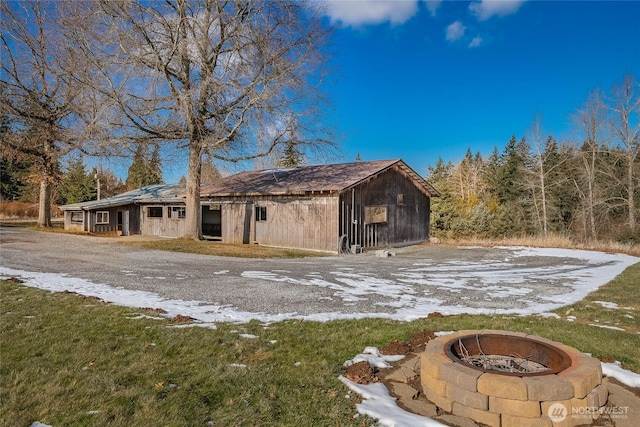 view of property exterior featuring an outdoor fire pit