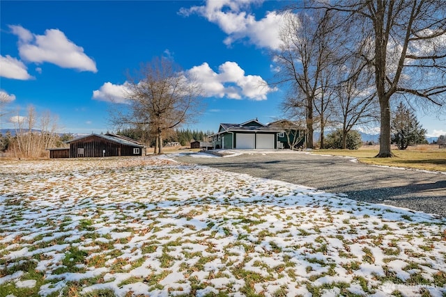 yard covered in snow featuring a garage