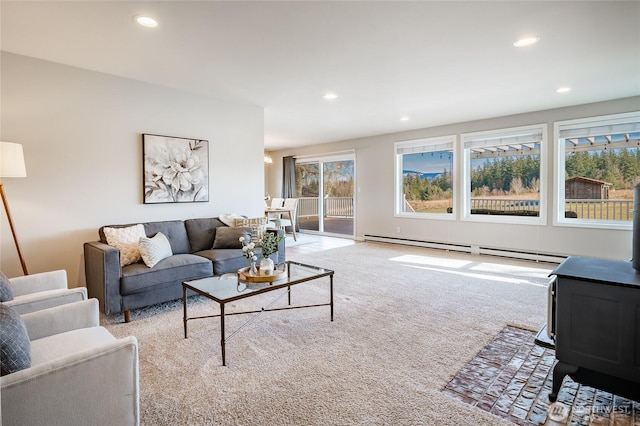 living room featuring a baseboard radiator, a wood stove, and light colored carpet