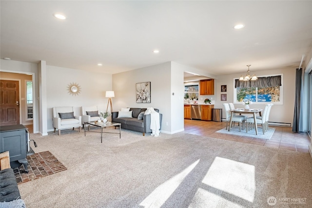 carpeted living room featuring a wood stove and a notable chandelier