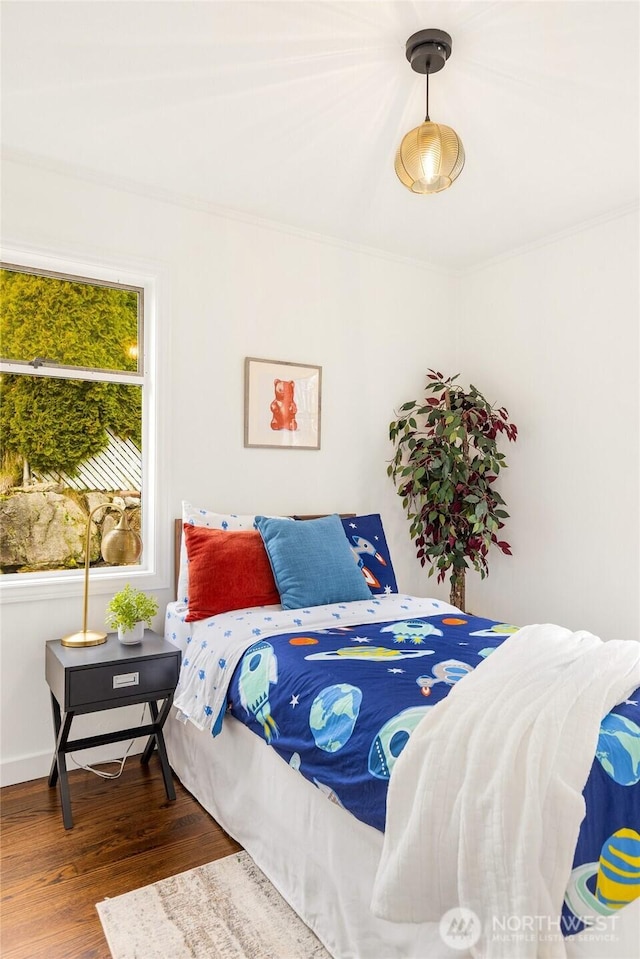 bedroom featuring wood finished floors and baseboards