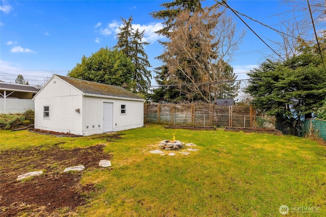 view of yard featuring an outdoor fire pit, an outdoor structure, and a fenced backyard