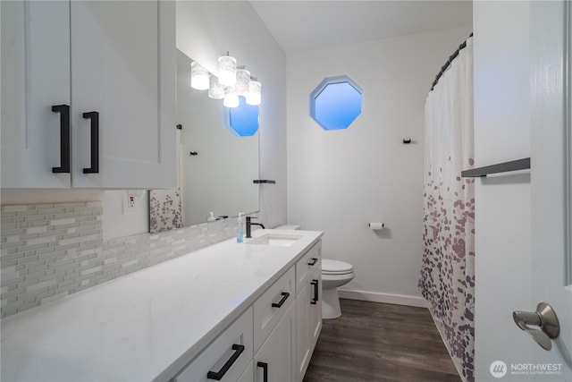 bathroom with toilet, wood-type flooring, vanity, and tasteful backsplash