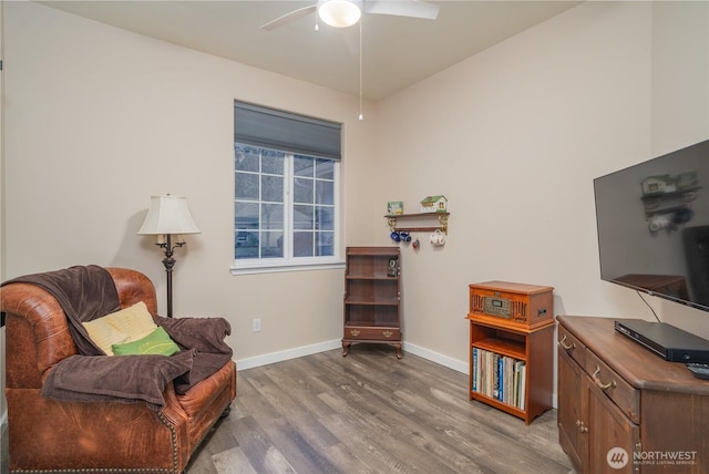 sitting room with ceiling fan and wood-type flooring