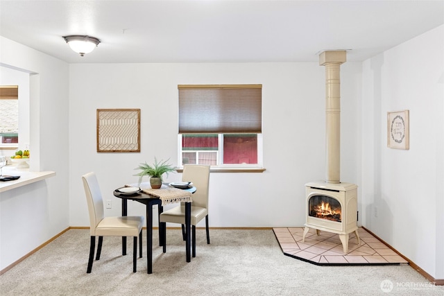 dining area featuring carpet flooring and a wood stove