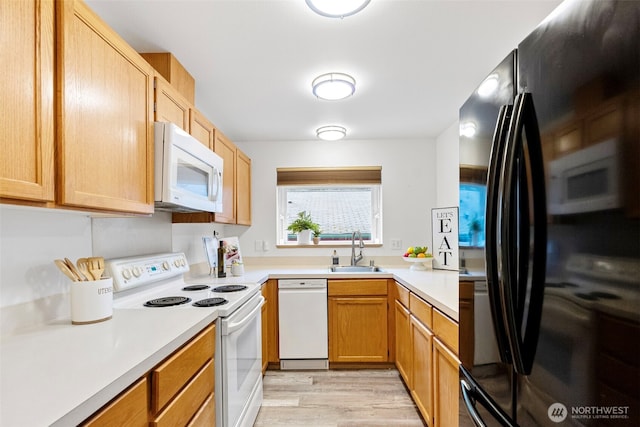 kitchen with white appliances, light hardwood / wood-style floors, and sink