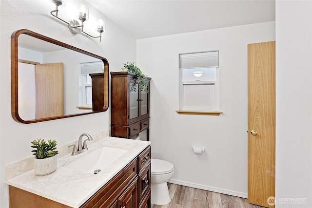 bathroom with hardwood / wood-style flooring, toilet, and vanity