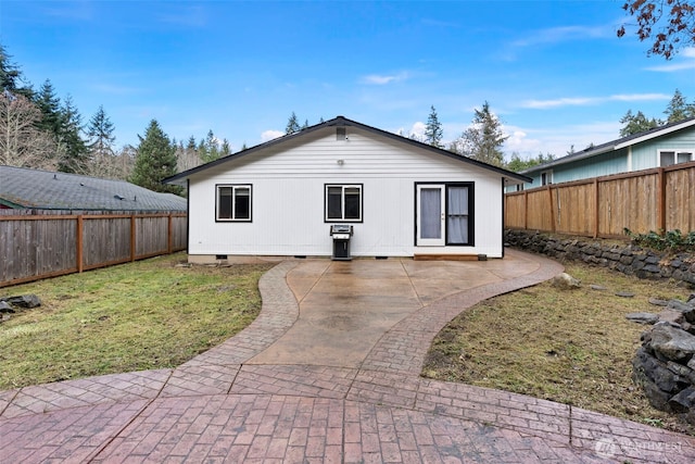 rear view of house with a patio and a lawn