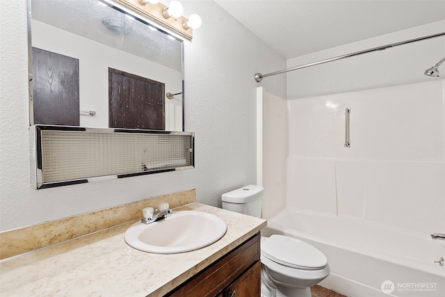 bathroom with  shower combination, a textured wall, vanity, and toilet