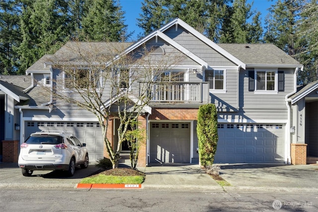 view of front facade featuring driveway, a balcony, a garage, and brick siding