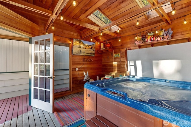 rec room with a jacuzzi, beam ceiling, wood walls, and wood ceiling