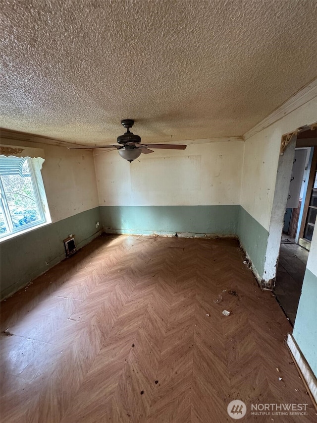 empty room with a textured ceiling, parquet floors, and ceiling fan