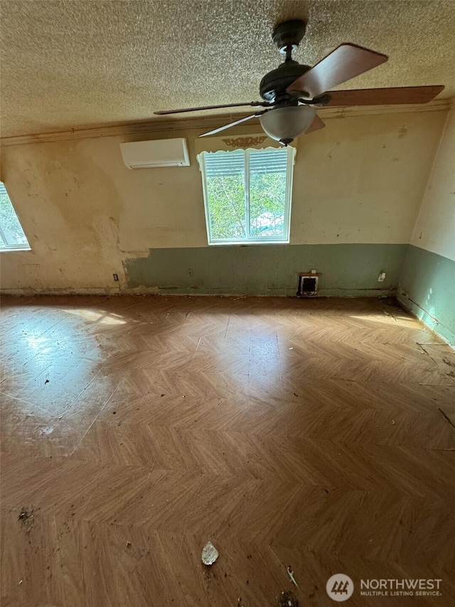 spare room with ceiling fan, light parquet floors, and a textured ceiling