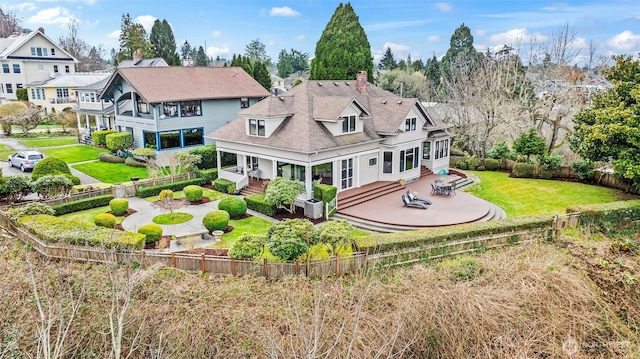 back of house featuring a patio, a yard, a fenced backyard, a fire pit, and a residential view