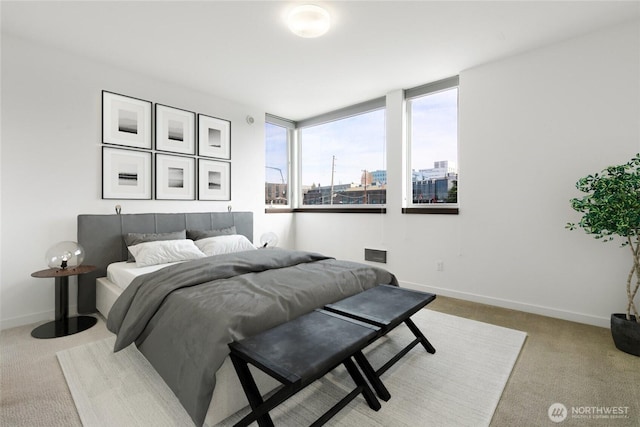 bedroom with a city view, light carpet, and baseboards