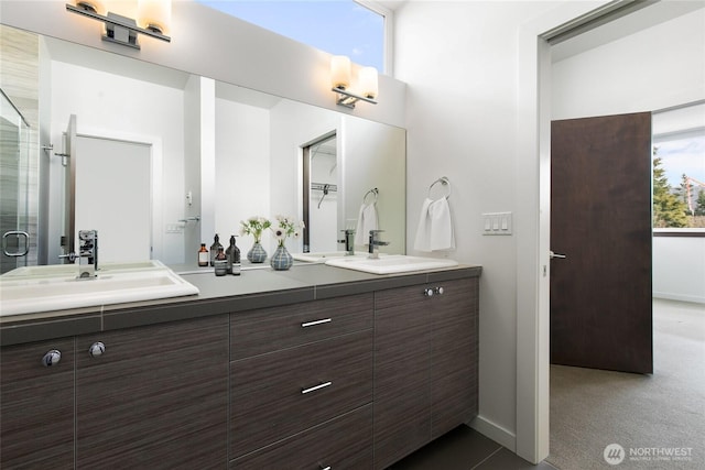 bathroom with double vanity, a stall shower, and a sink