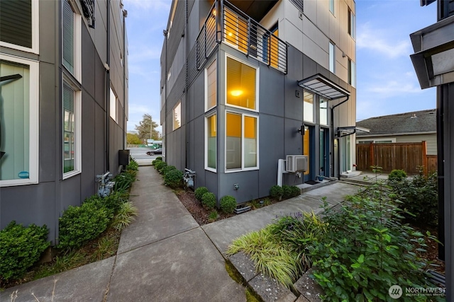 view of side of home with fence and stucco siding