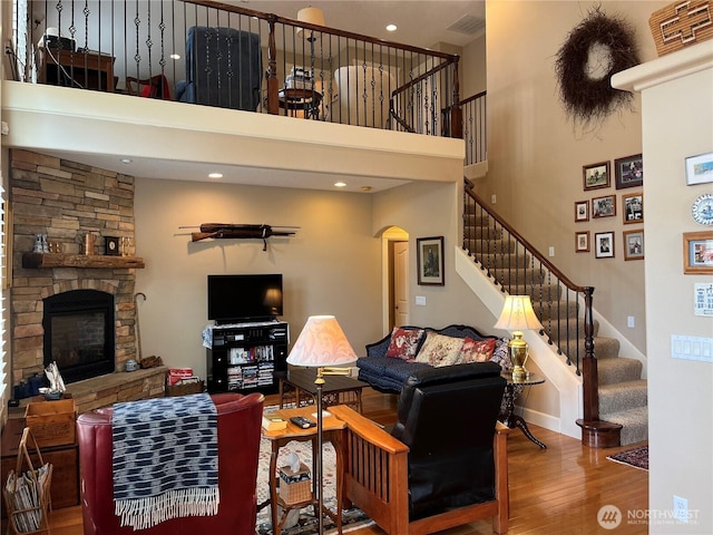 2611 Sea Crest Ave N, Long Beach, WA 98631 - living area featuring a towering ceiling, wood finished floors, arched walkways, stairs, and a stone fireplace
