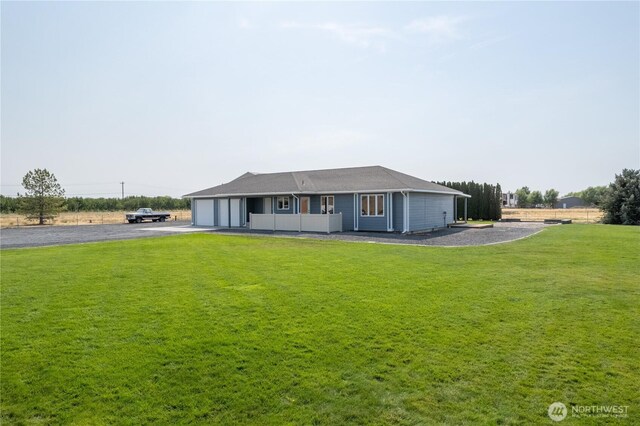 single story home featuring an attached garage, aphalt driveway, and a front yard