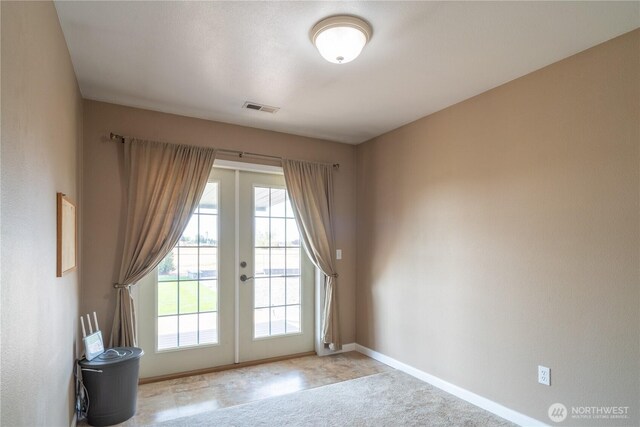 entryway with light carpet, french doors, visible vents, and baseboards