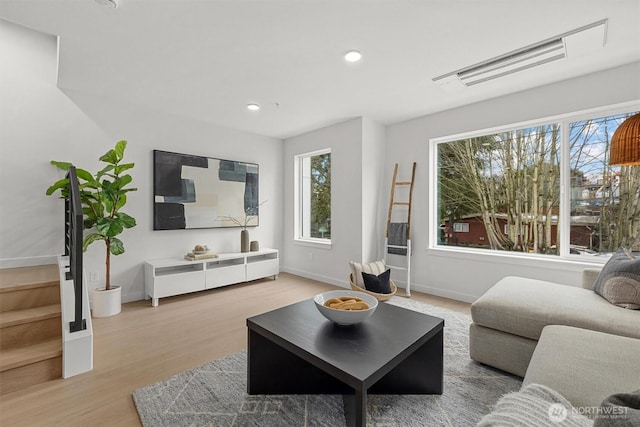 living area featuring recessed lighting, light wood-type flooring, and baseboards