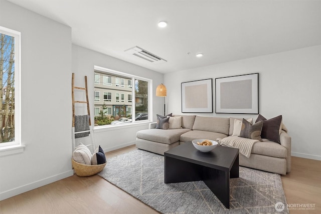 living area featuring visible vents, recessed lighting, baseboards, and wood finished floors