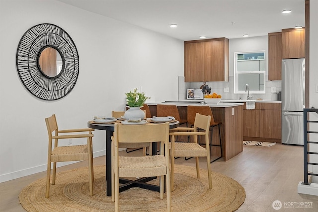 dining space with recessed lighting, light wood-style floors, and baseboards