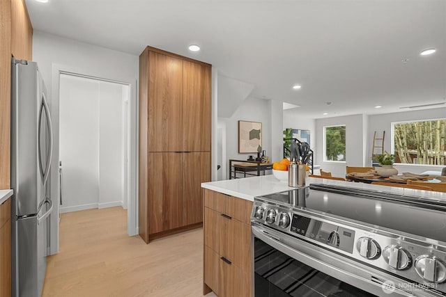 kitchen featuring light wood-type flooring, light countertops, recessed lighting, stainless steel appliances, and modern cabinets